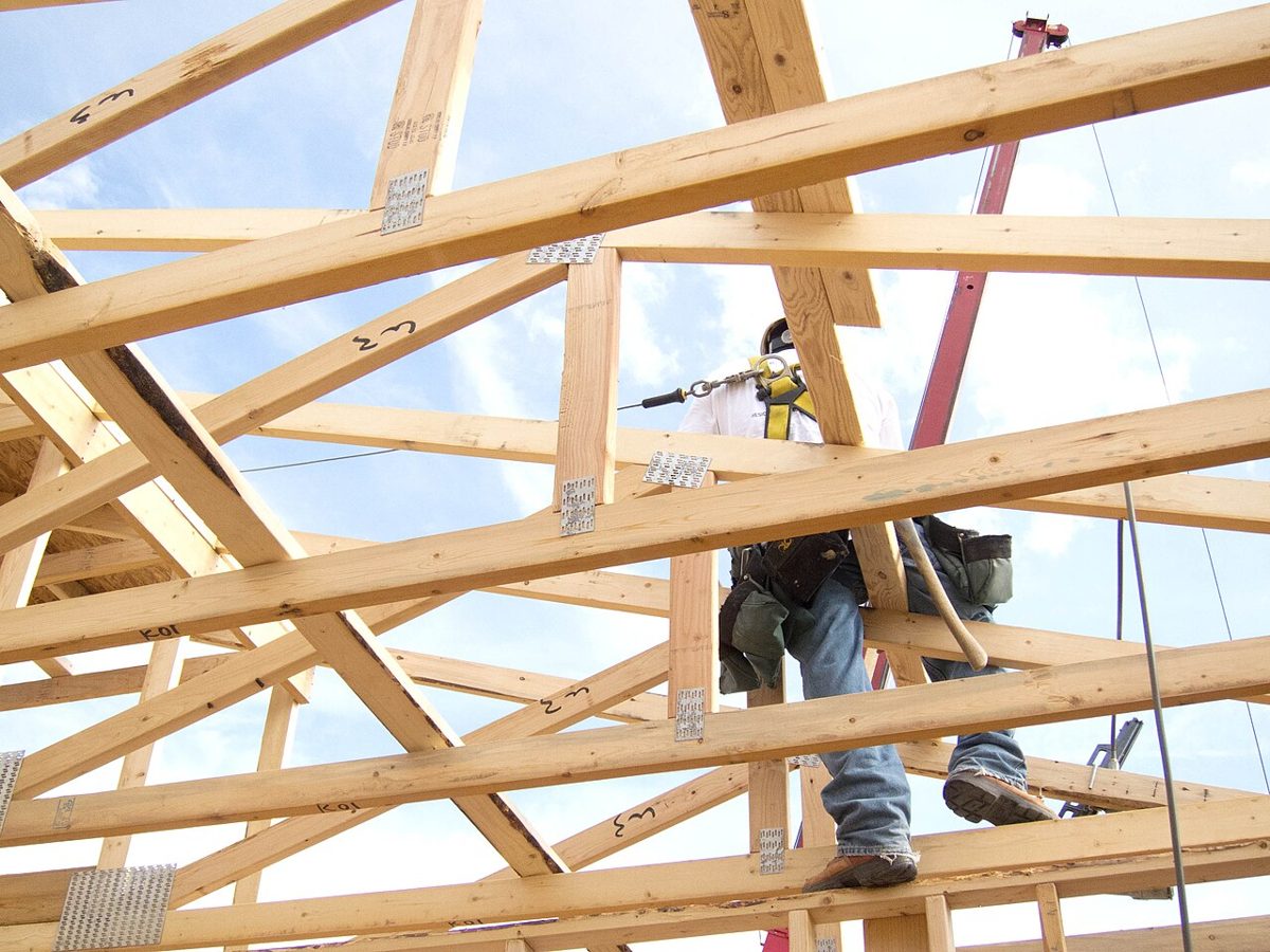 Carpenter working on roof trusses with fall prevention in place